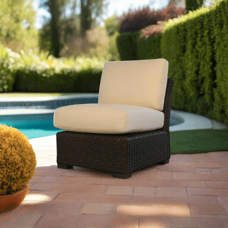 Outdoor chair with beige cushions on a patio near a pool