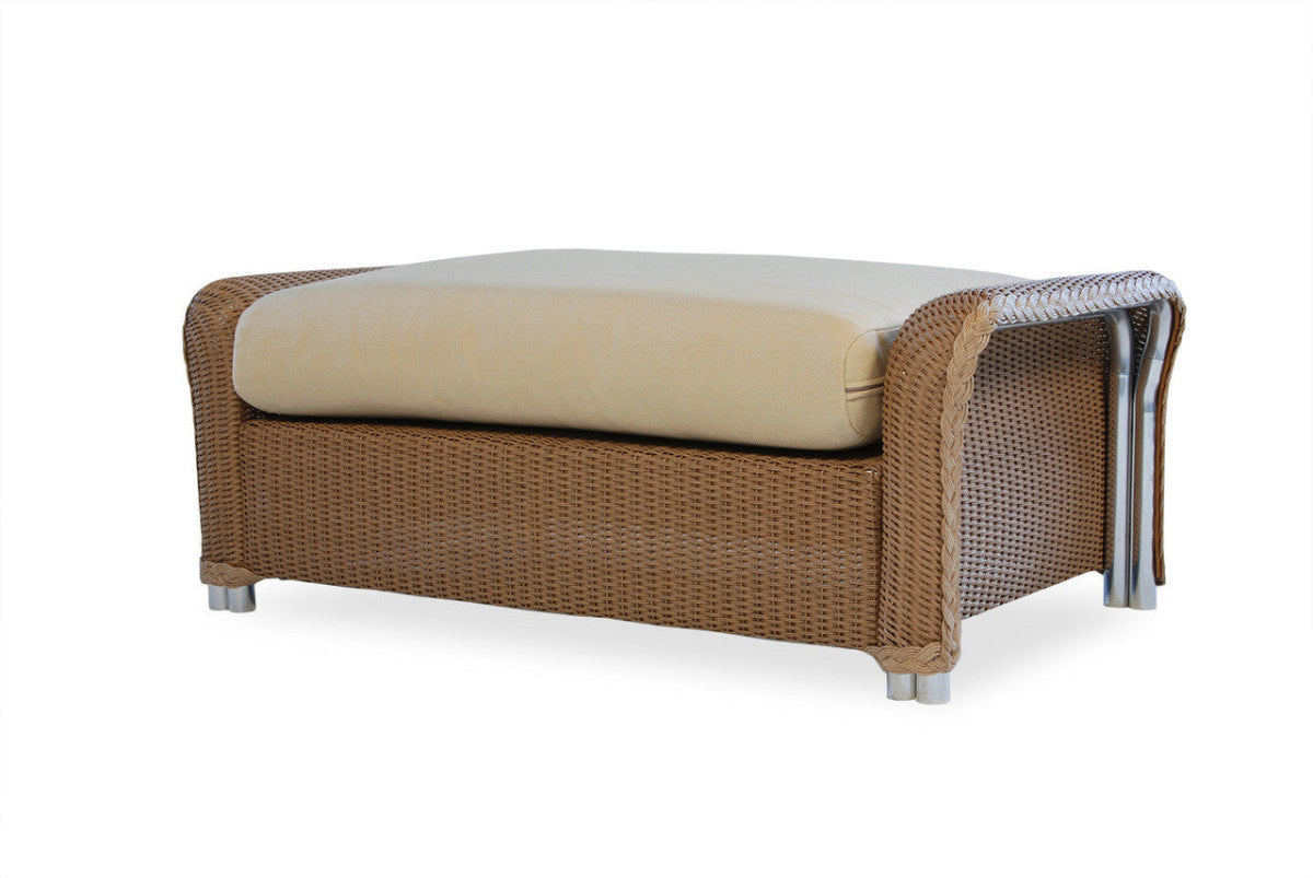 A large wicker ottoman with a beige cushion, featuring a robust frame made of welded aluminum, designed for outdoor use.