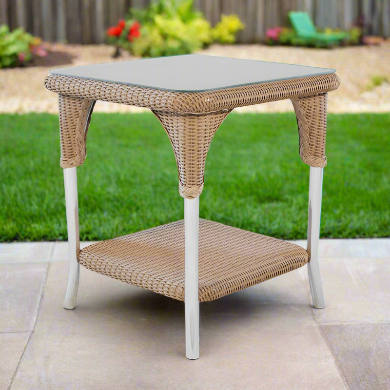 Wicker side table with a gray cushion top on a patio