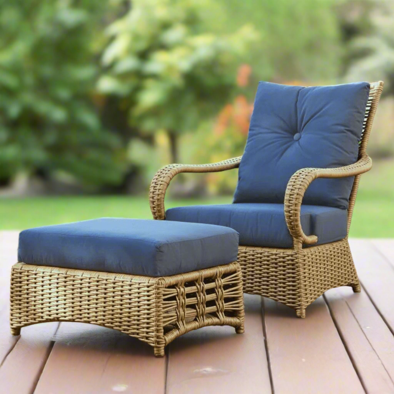 Wicker chair and ottoman set with blue cushions on a wooden deck