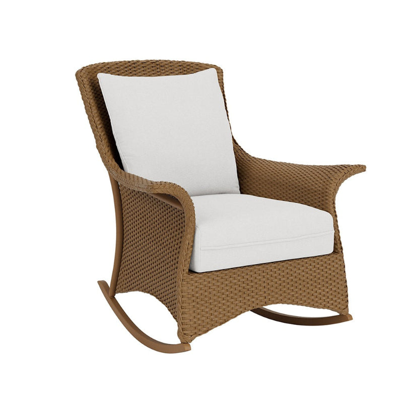 Brown wicker rocking chair with white cushions on a white background