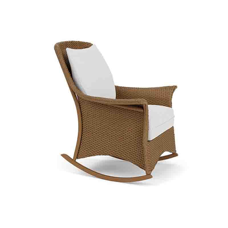 Brown wicker rocking chair with white cushions on a white background