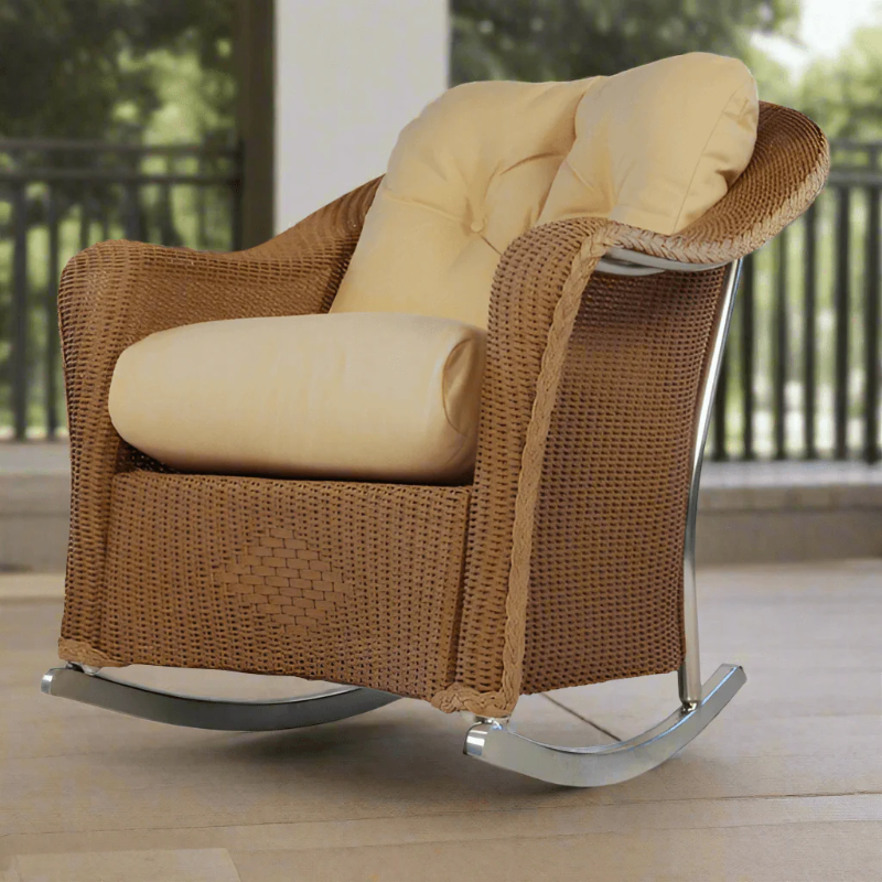 Brown wicker rocking chair with beige cushions on a patio