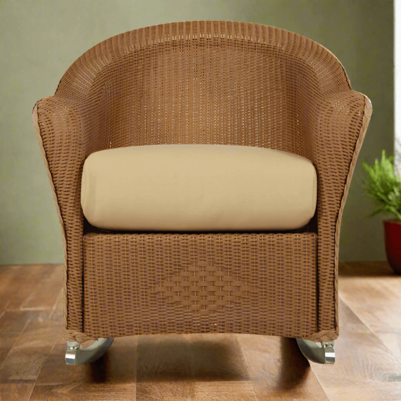 Brown wicker armchair with beige cushion on a wooden floor.