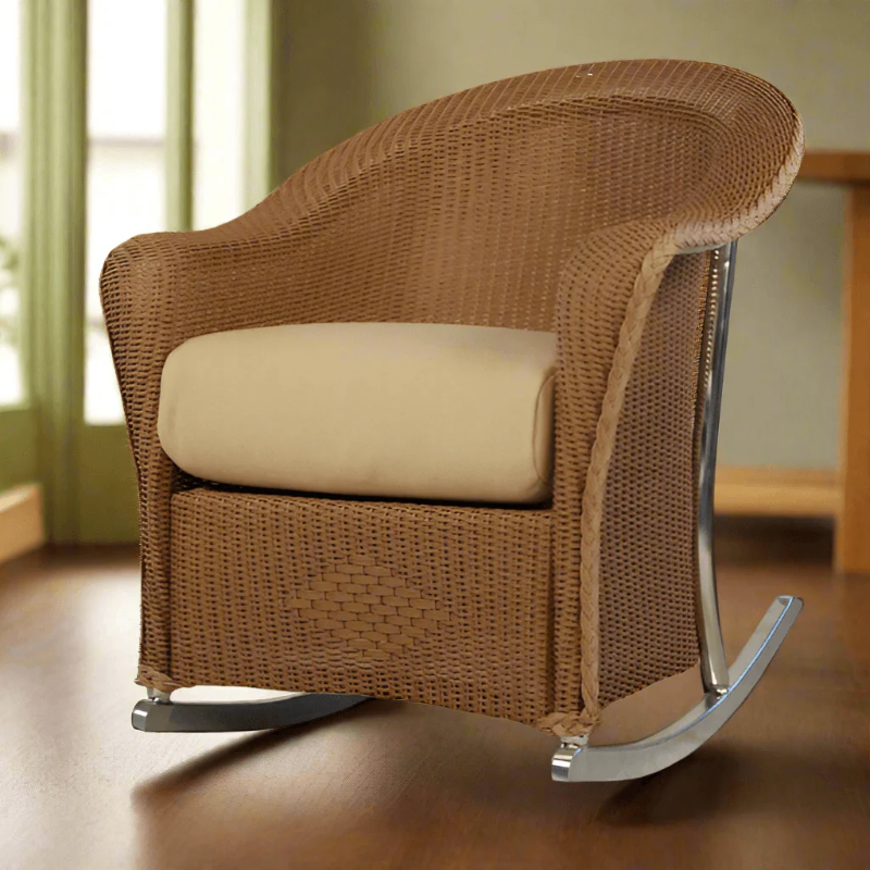 Brown wicker rocking chair with a beige cushion on a wooden floor.