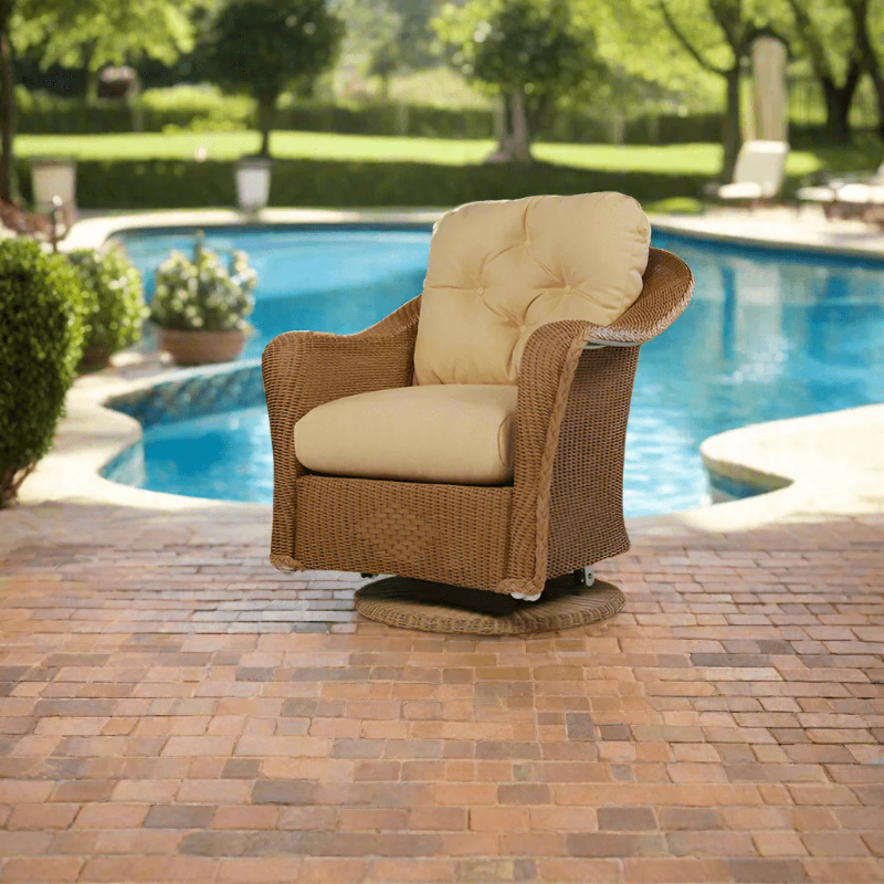 Brown wicker chair with beige cushions by a pool