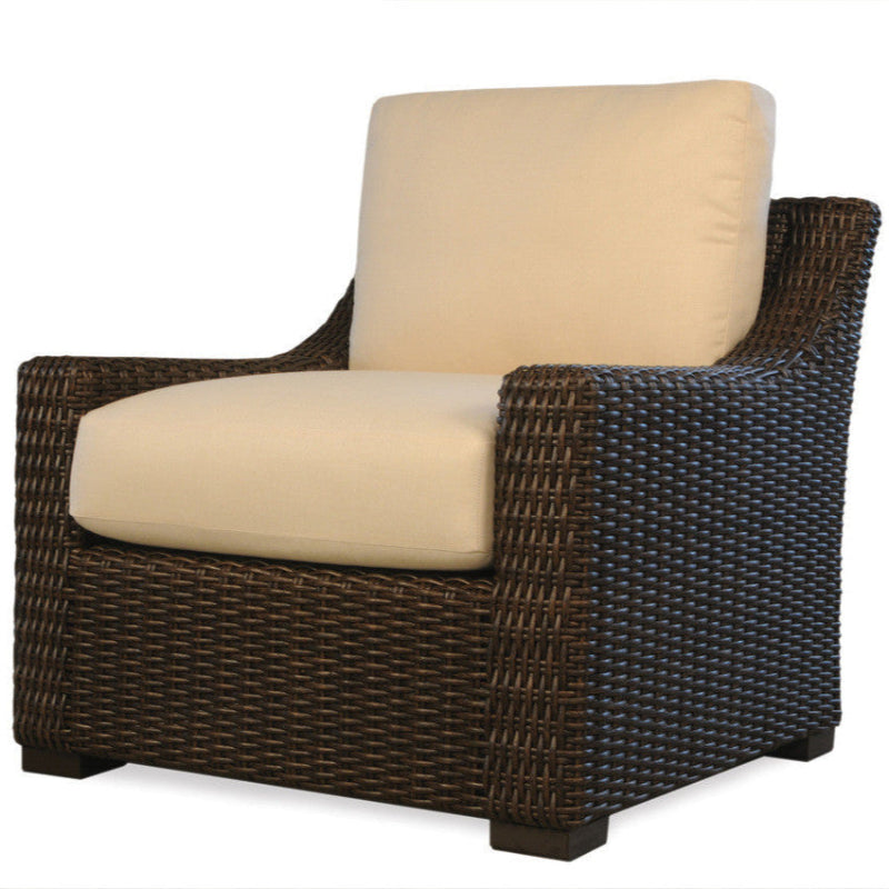 Wicker chair with beige cushions on a white background