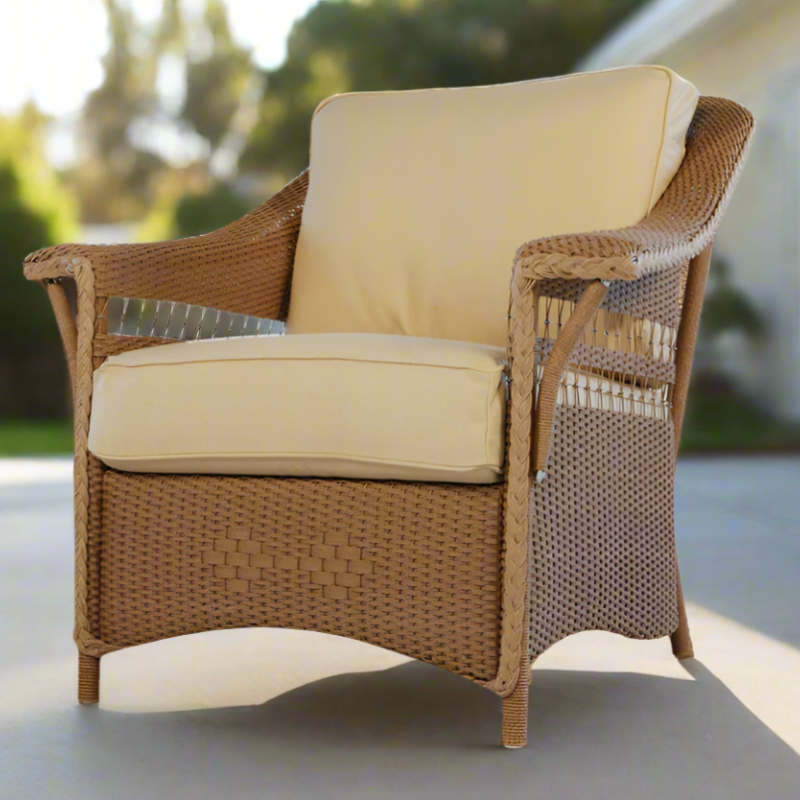 Wicker chair with beige cushions on a patio