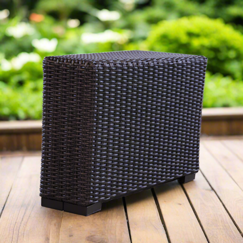 Woven outdoor stool on a wooden deck with greenery in the background