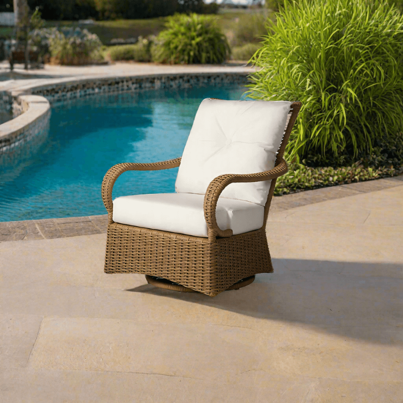 Wicker chair with white cushions by a poolside