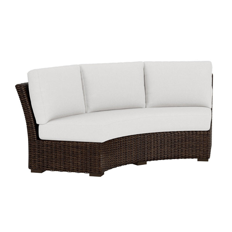 Wicker outdoor sofa with white cushions on a white background