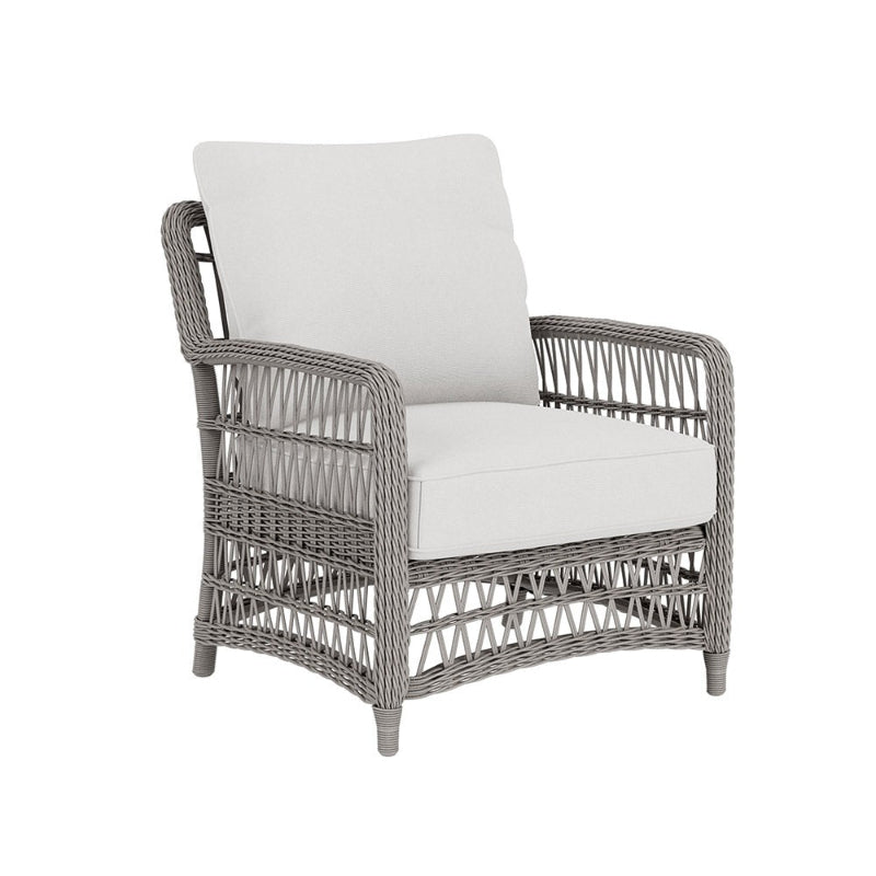 Wicker armchair with white cushions on a white background