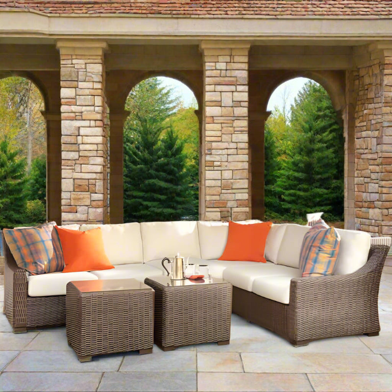 Outdoor patio furniture set with cushions on a stone patio.