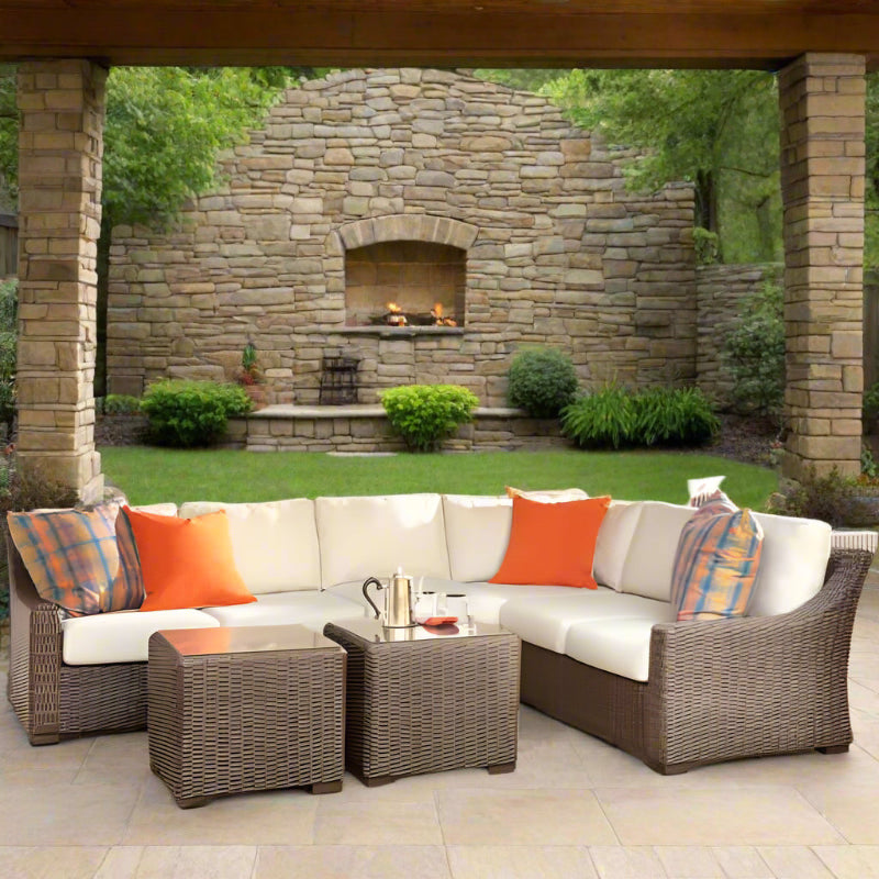 Outdoor patio furniture set with cushions on a stone patio.