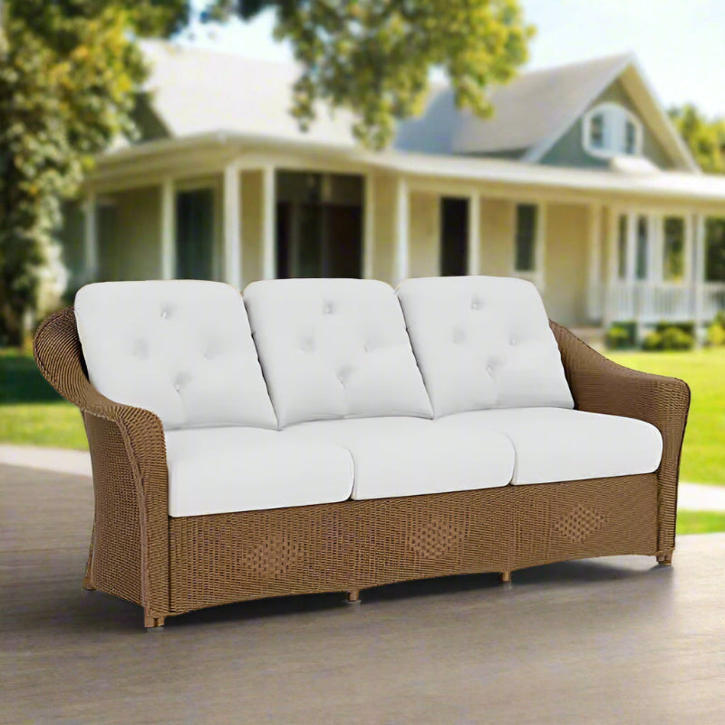 Sofa with brown wicker frame and white cushions on a white background