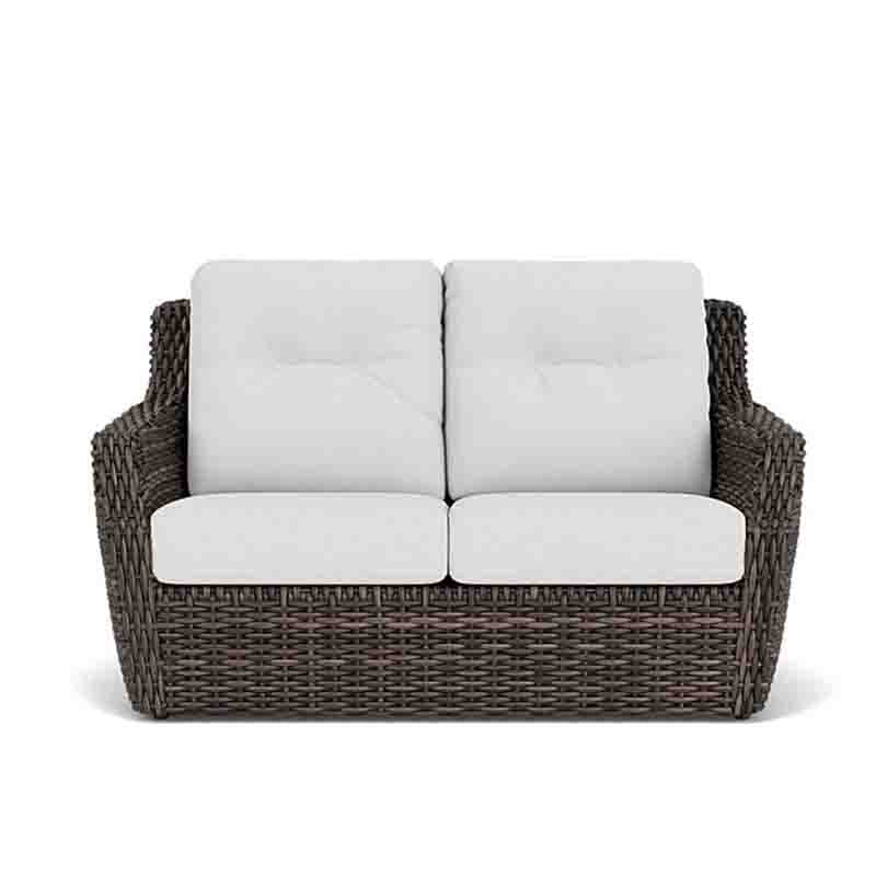 Wicker loveseat with white cushions on a white background