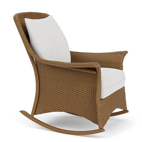 Brown wicker rocking chair with white cushion on a white background