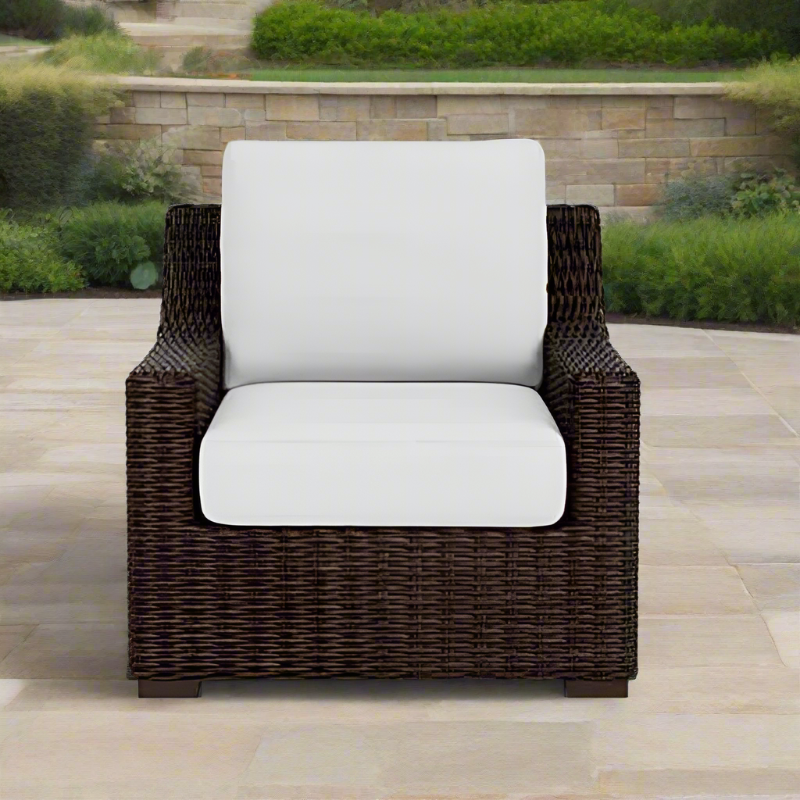Wicker chair with white cushions on a patio