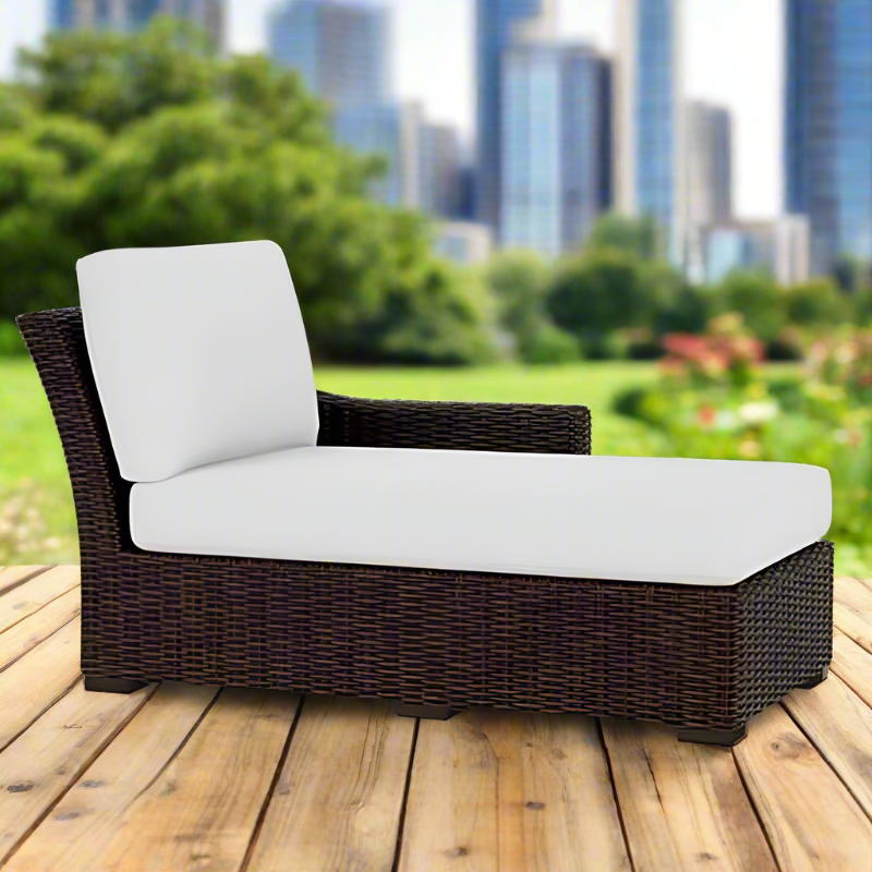 Wicker outdoor lounge chair with white cushions on a wooden deck, cityscape in the background