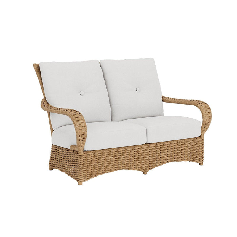Wicker loveseat with white cushions on a white background