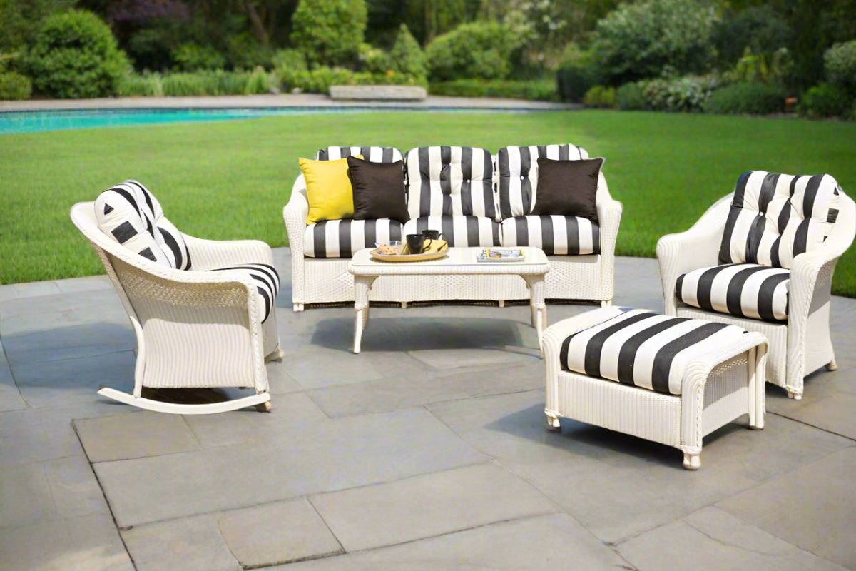 Outdoor patio set with striped furniture on a stone patio.