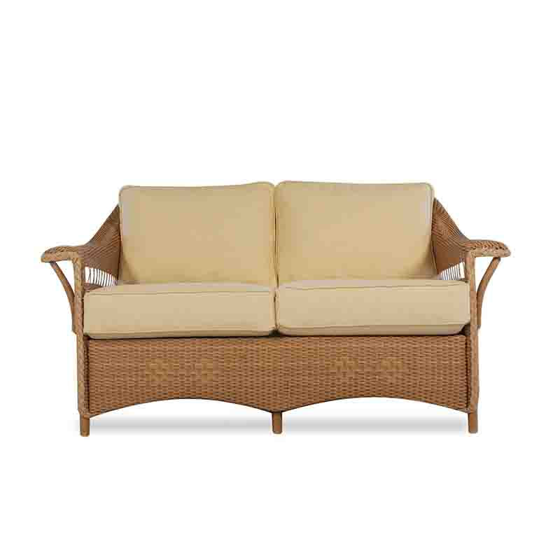 Wicker outdoor sofa with beige cushions on a white background