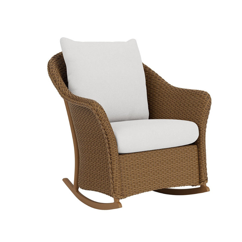 Brown wicker rocking chair with white cushions on a white background