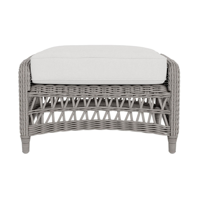 Wicker ottoman with a white cushion on a white background