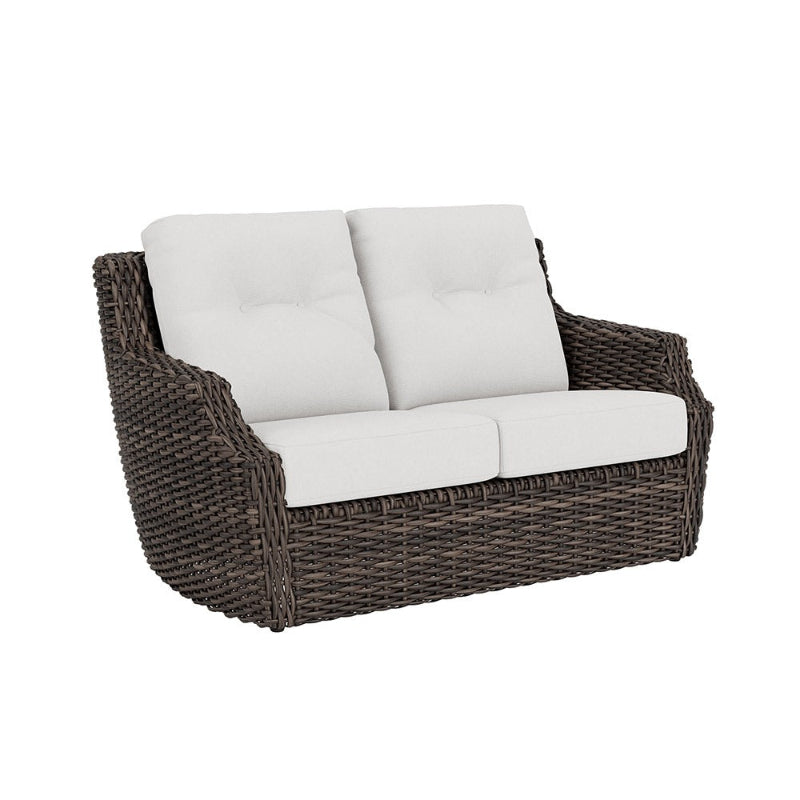 Wicker loveseat with white cushions on a white background