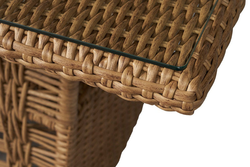 Close-up of a wicker table with a glass top on a white background
