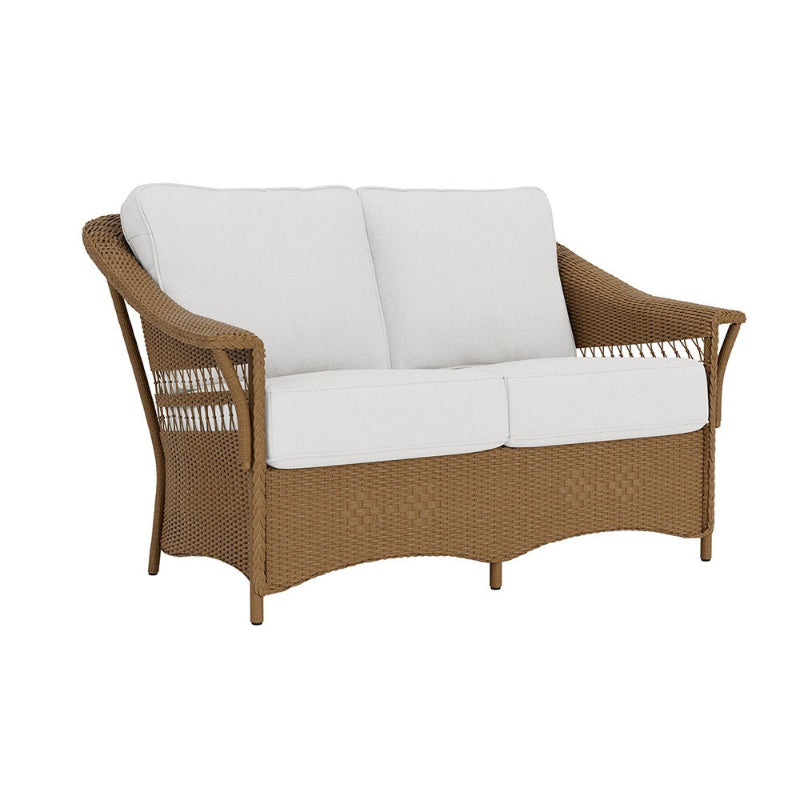 Wicker outdoor sofa with white cushions on a white background