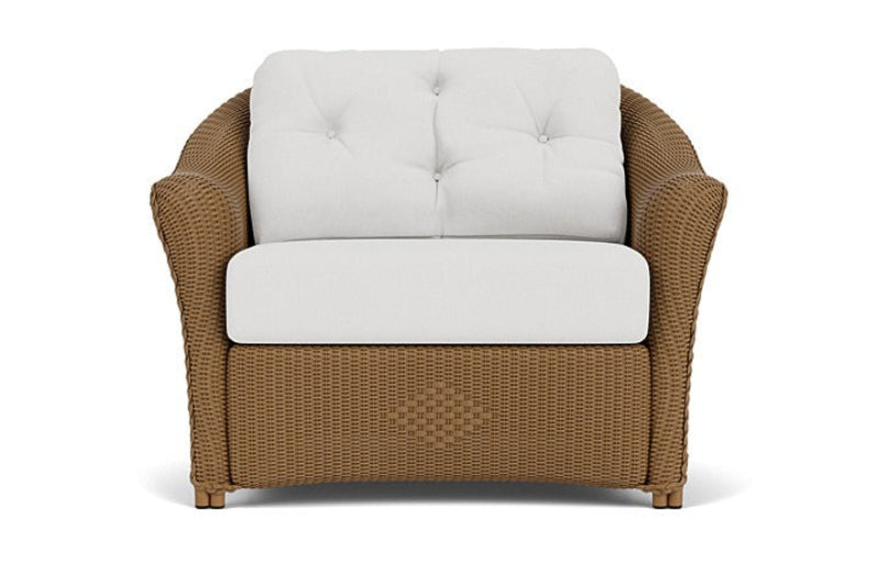 Brown wicker armchair with white cushions on a white background