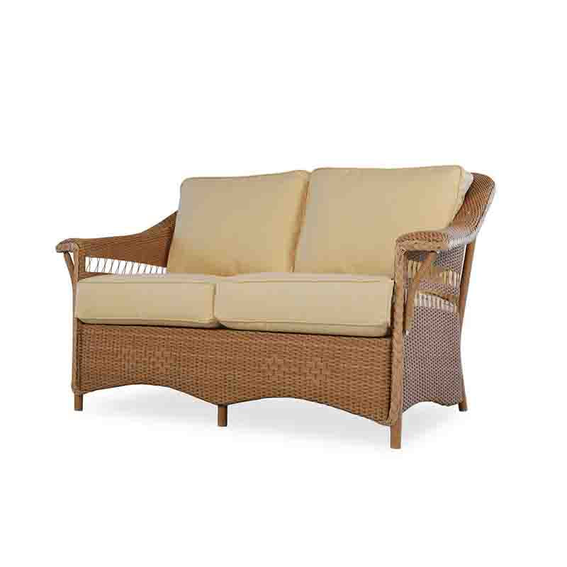 Wicker outdoor sofa with beige cushions on a white background