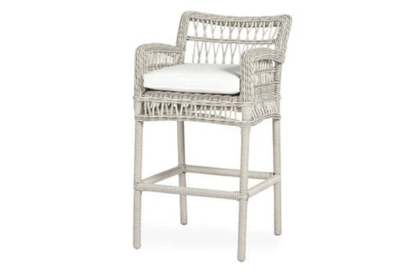 Wicker bar stool with a white cushion on a white background