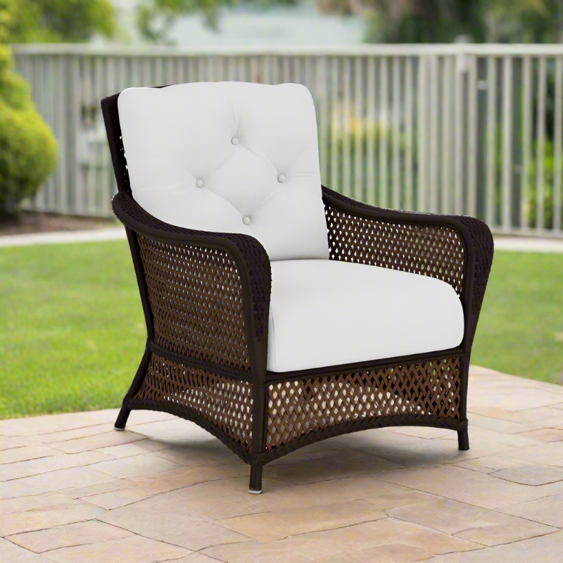 Wicker chair with white cushion on a patio