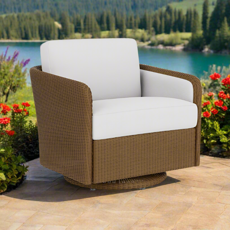 Brown wicker chair with white cushions on a patio with a scenic background