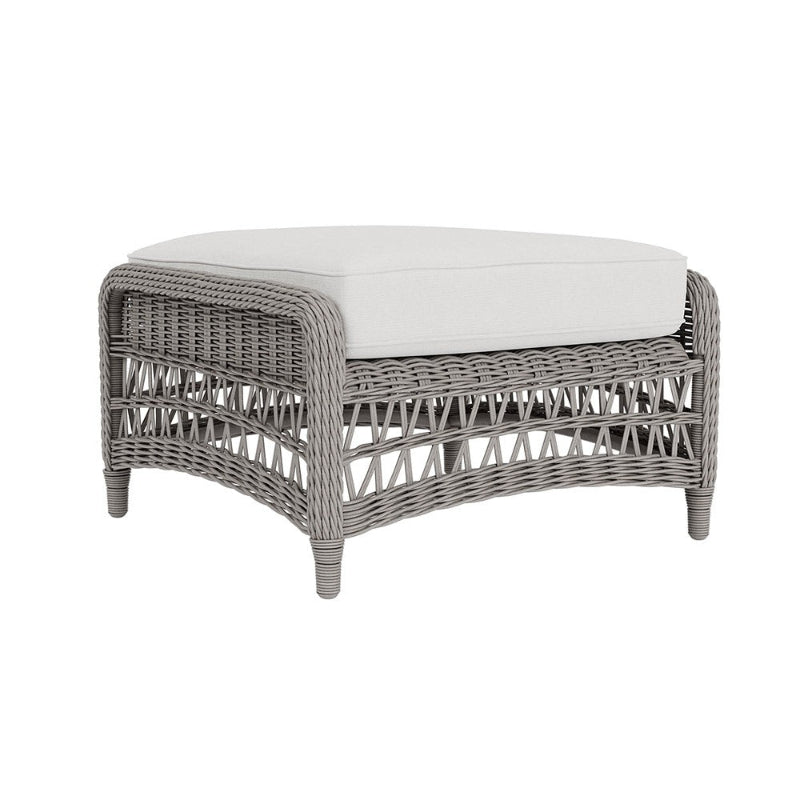 Wicker ottoman with a white cushion on a white background