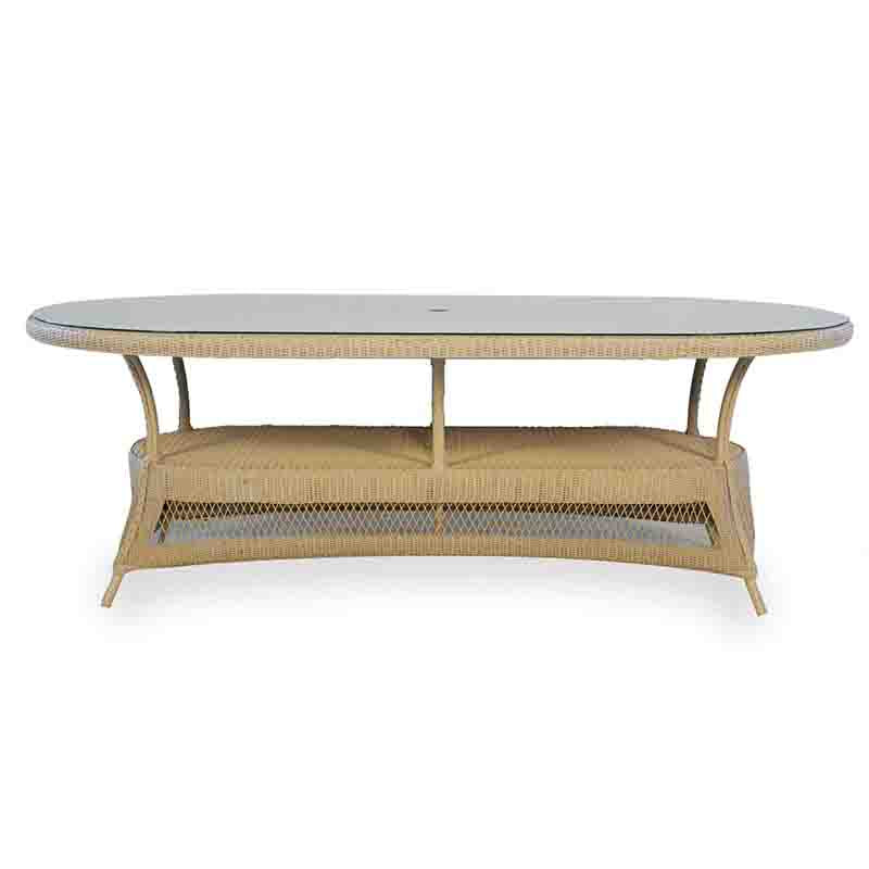 Oval-shaped coffee table with wicker frame and glass top on a white background