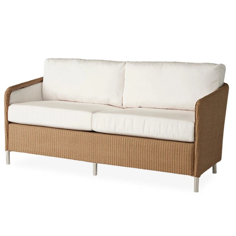 Brown wicker outdoor sofa with white cushions on a white background