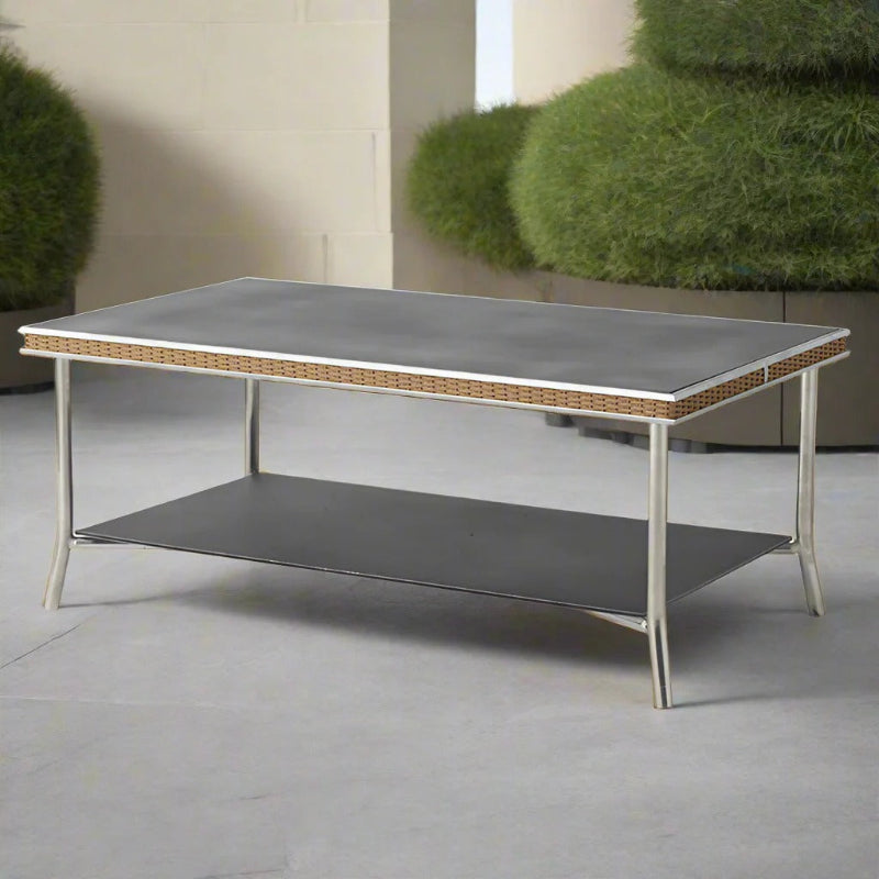 Modern outdoor coffee table with a gray top and metal frame on a patio.