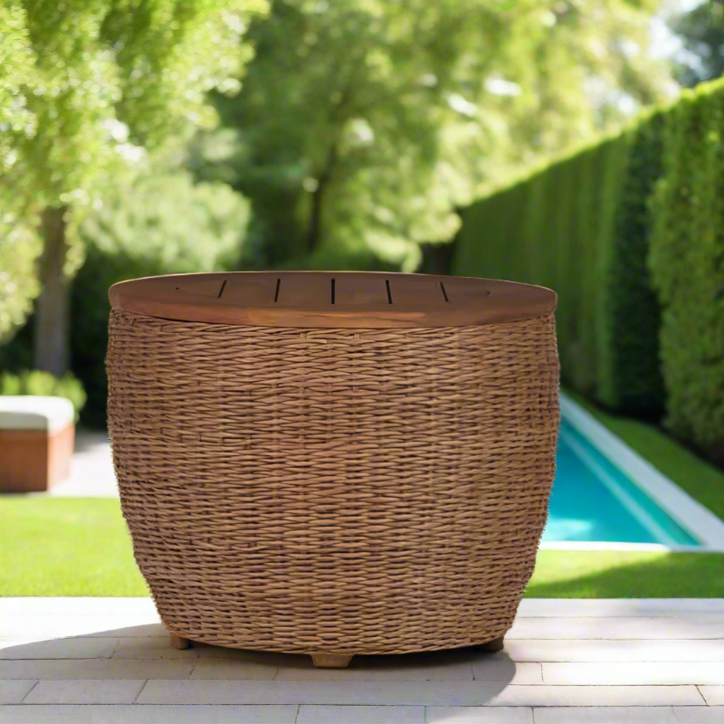 Wicker planter on a patio with a pool and greenery in the background