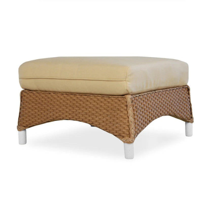 Wicker ottoman with beige cushion on a white background
