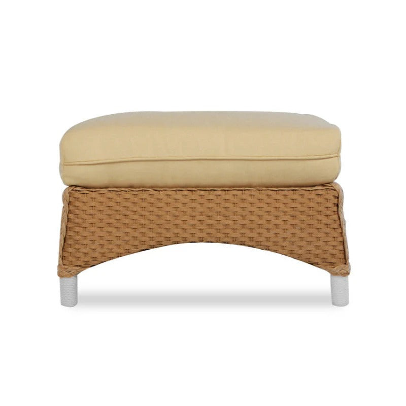 Beige cushioned ottoman with wicker frame on a white background