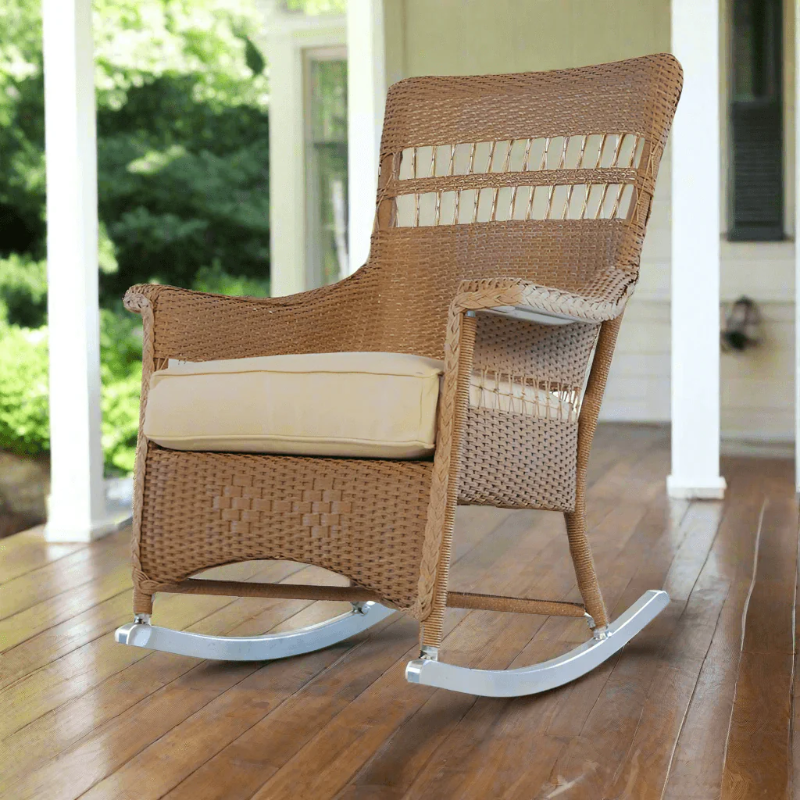 Wicker rocking chair with beige cushion on a wooden porch