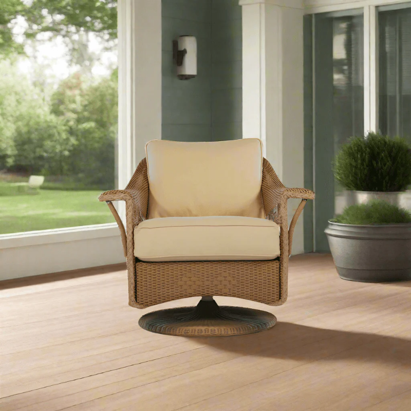 Wicker chair with beige cushions on a wooden deck