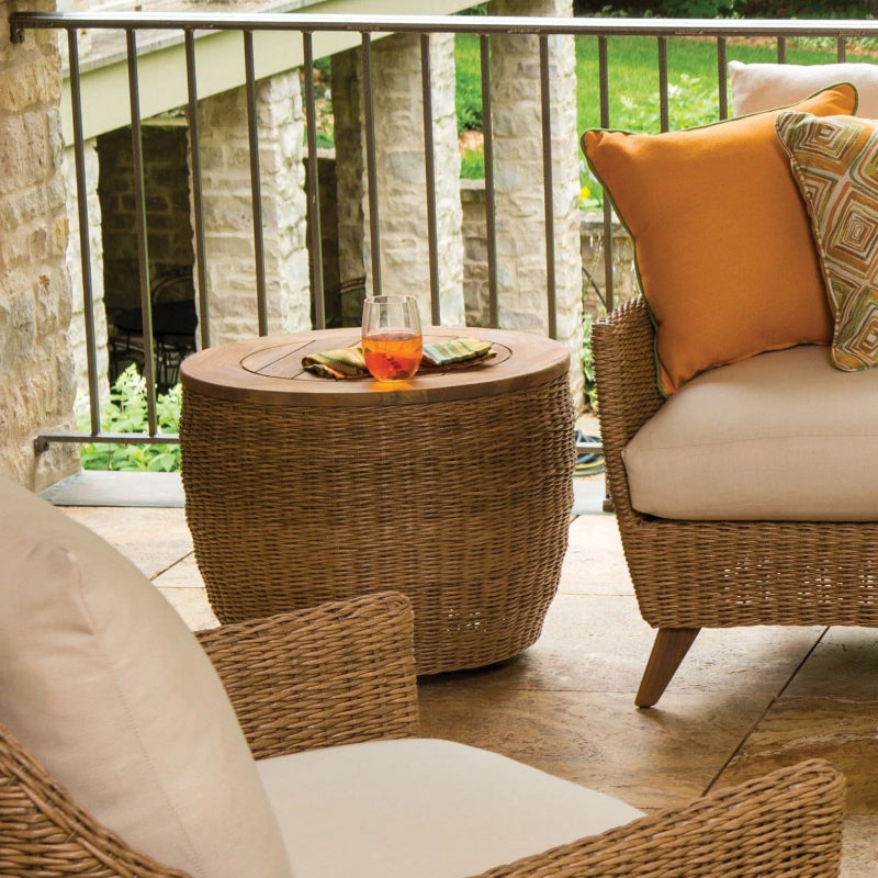 Outdoor patio setting with wicker furniture and a glass of tea on a small table.