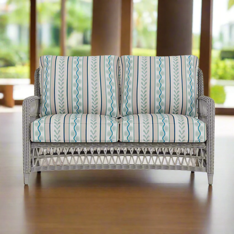 Wicker loveseat with striped cushions in a bright room