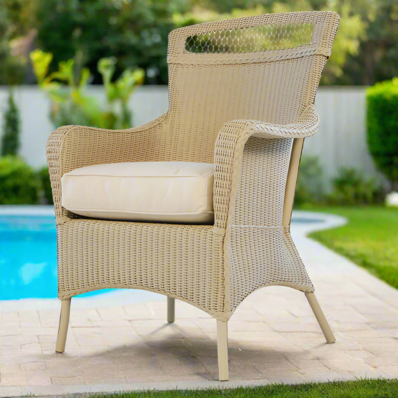 Wicker chair with a cushion on a patio by a pool